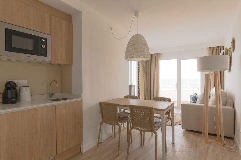 Cocina, comedor y salón con vistas al mar de un apartamento de Leomar Ses Roquetes