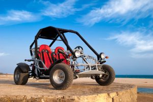 Buggy con los asientos rojos en una playa.